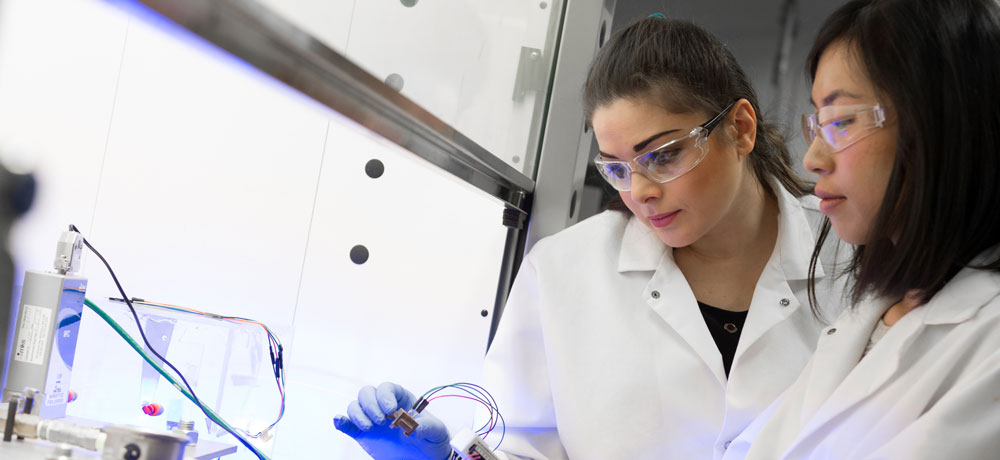 Mechanical Engineering professor Mina Hoorfar works in a lab with student.