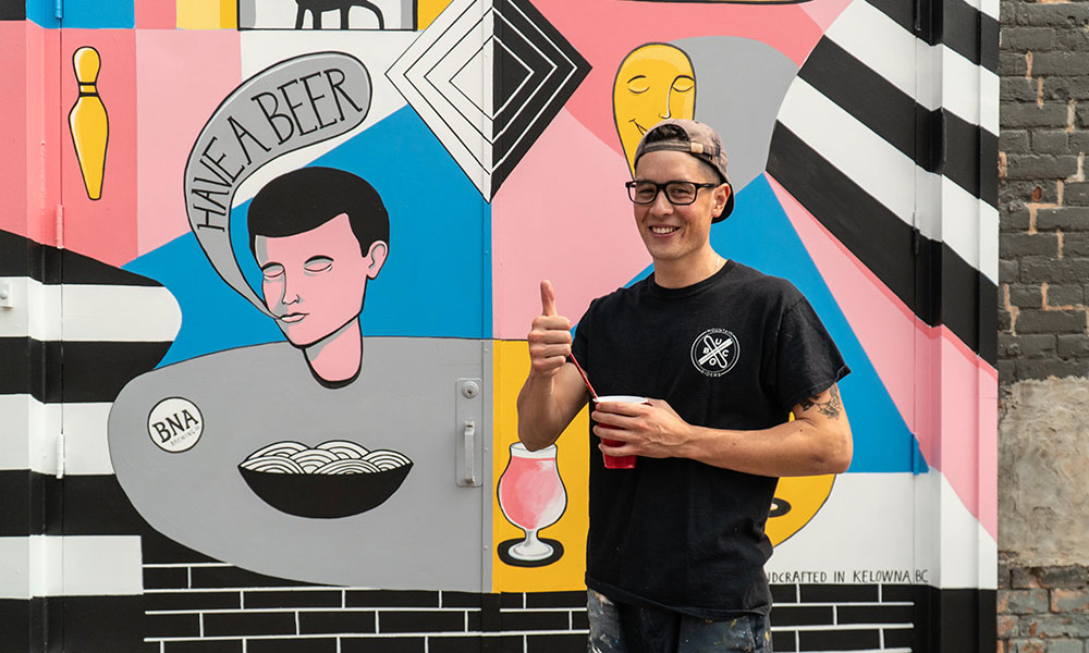 Ben Arcega in front of his BNA Brewing mural
