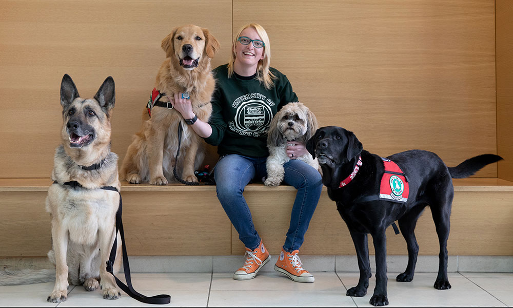Freya Green sitting with four therapy dogs