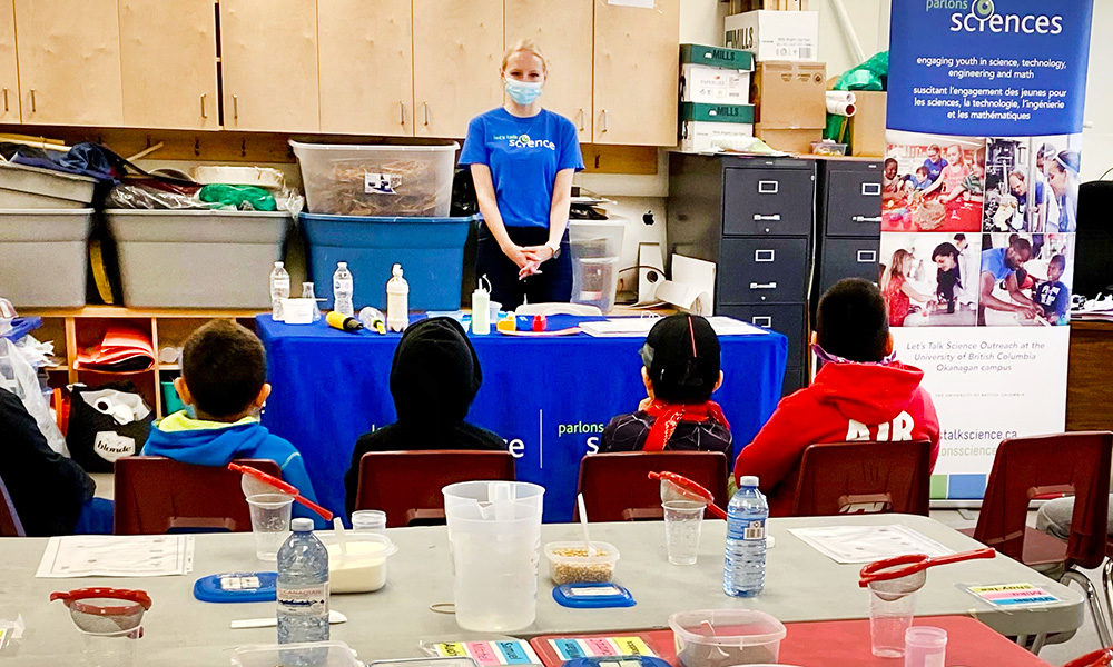 A teacher standing in front of students with STEM supplies in the foreground