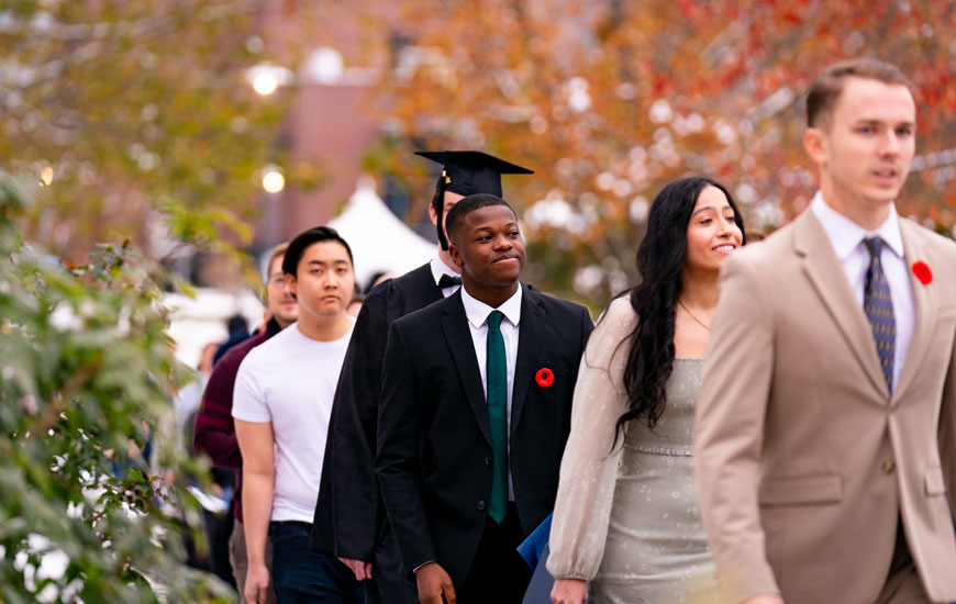 Alumn walking to the fall graduation ceremony.