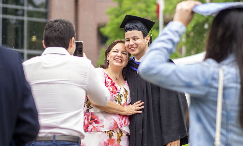 A graduating student takes a photo with their parent.