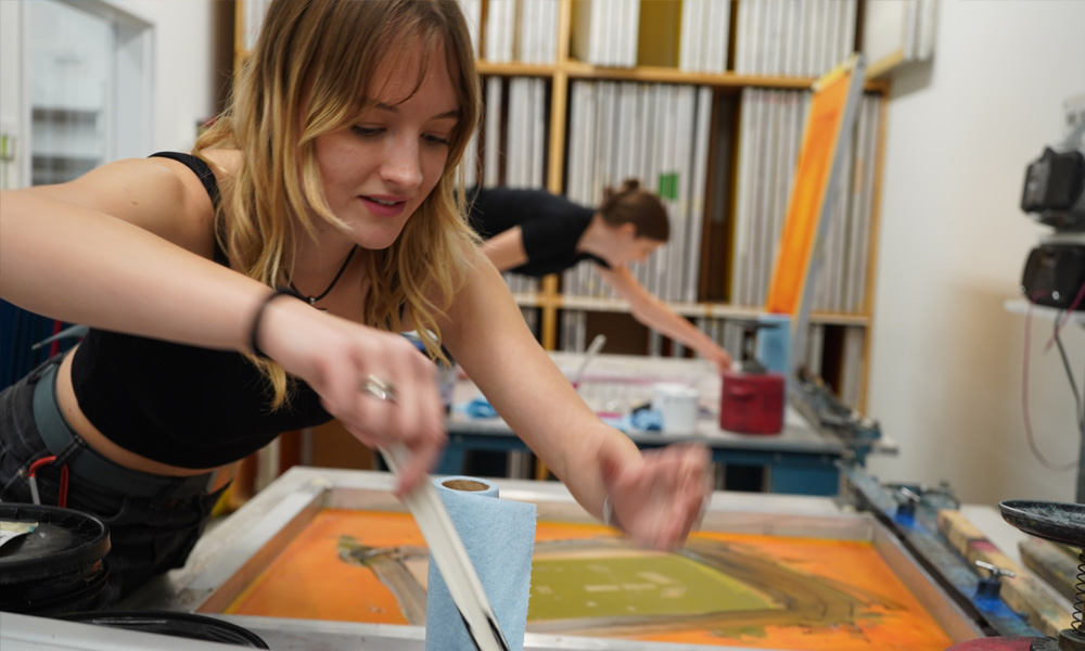 Students add ink to their screens during the screen printing process, in UBCO's printmaking studio